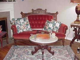 Red upholstered settee, pierced frame, Victorian era
