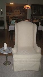 Upholstered cream colored chair, small marble top table