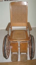 Antique wooden wheel chair with rattan back and seating- early 1900s