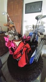 golf clubs, bag chairs, tire, "bar" sign, and old door     GARAGE