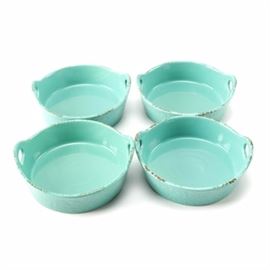 Blue Jean Chef Handle Ceramic Bowls: A set of ceramic bowls by Blue Jean Chef. These four matching bowls feature handles at either end and textured teal colored surfaces with glazed finishes. The underside of each is stamped “Blue Jean Chef”.