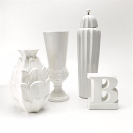 Glazed Ceramic Home Decor: A collection of glazed ceramic home decor. There are four pieces including one vase, one urn with a matching lid, one pineapple shaped piece, and a letter “B” decor piece. They are each white in color and are marked to the bottoms.
