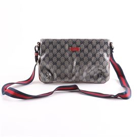Gucci Crystal Monogram Small Messenger Bag: A Gucci Crystal Monogram Small Messenger bag. This crossbody bag hangs from an adjustable red and blue striped web strap. It features a coated monogram patterned canvas body with leather trim accents. A red leather Gucci logo is present to the front. The interior is branded further and is marked with the serial number, 189749 001998. A Gucci dust bag is included.