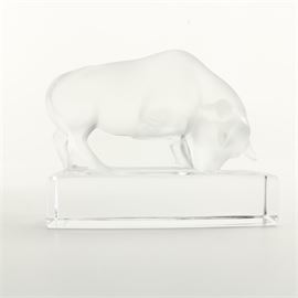 Lalique Crystal Bull Paperweight: A Lalique French art crystal bull. This features a Lalique frosted crystal bull paperweight on a rectangular clear crystal base with beveled cut upper edges. The piece is etched on the base “Lalique France”.