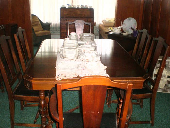 Another view of the beautiful table with 3 leaves, table pads, six chairs and matching buffet and china cabinet.