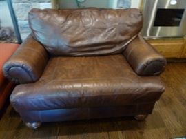 Two oversized matching leather chairs with ottomans
