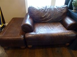 Two oversized matching leather chairs with ottomans