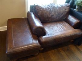 One of two oversized leather chairs with ottoman