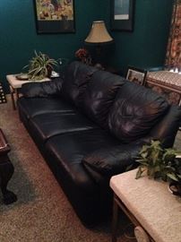 Extra comfortable black sofa has matching chairs and ottomans