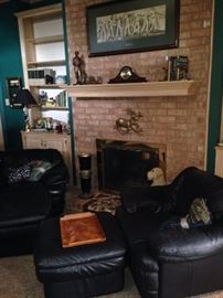 Two black chairs and ottomans match the sofa.