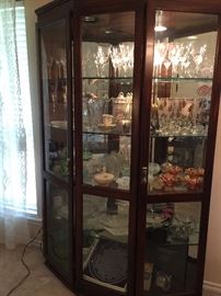 Large lighted display cabinet with glass shelves and mirror back.  This display case is full of vintage, Fenton, Carnival, Moon Stone, Mikasa, Vaseline, German China.