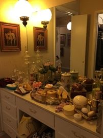 The bathroom has more of the French Ivory collection, large glass containers, and other vintage bathroom items.