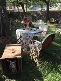 There are two vintage metal garden tables, two metal garden chairs, wood dog crate