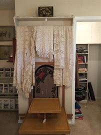 Handing quilt rack with shelf, vintage crochet bed coverlets and table clothes, antique hook rug frame with hook rug, mid century table