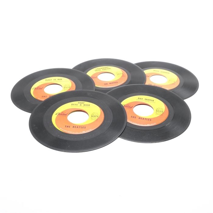 Collection of The Beatles 45s from Capitol Records: A collection of The Beatles 45s on orange/yellow label Capitol Records. This collection features singles by The Beatles including “Hello Goodbye” #2056, “Eight Days a Week” #5371, “Day Tripper” #5555, “Ticket to Ride” #5407, and “Strawberry Fields Forever” #5810. Each record features the yellow/orange swirl Capitol records label.