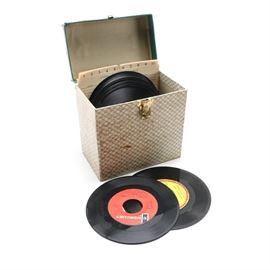 Vintage 45 RPM Carrying Case With Singles Including Bob Dylan and The Byrds: A record carrying case and group of 45 rpm singles. This papered case has a brass tone latch and holds twenty-two records including She Don’t Care About Me from The Byrds, Last Train to Clarksville from The Monkees, and Gates of Eden by Bob Dylan. Other musicians include The Lovin’ Spoonful, Eddie Jason, The Supremes, and Shirley Bassey.