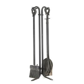 Black Iron Fireplace Tool Set: A set of fireplace tools. This set includes a stand and four pieces, featuring a pair of tongs, brush, poker, and shovel. These pieces are made of iron with a black matte finish.