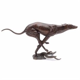 Cast Bronze Whippet Sculpture, By Ki Herman: A cast bronze sculpture of a running whippet. Cast in an expressive pose with an outstretched torso. Signed to lower leg “Ki Herman”.