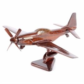 Wooden Propeller Plane Model with Stand: A wooden propeller plane model with stand. This handmade high glossed mahogany piece has a few loose joints and stands on a triangular base. No signature or marks found.