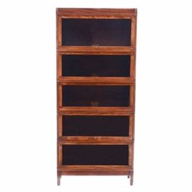 Vintage Globe-Wernicke Bookcase: A circa early 20th century vintage barrister style bookcase by Globe-Wernicke of Cincinnati, in oak and cherry. It has four stacking shelves with swing-up glass doors, plus a top and base piece. It retains its original labels to the shelf interiors.