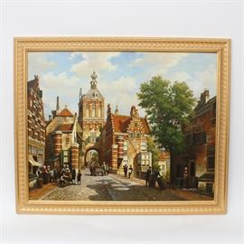 Maria Estaphan Oil Painting on Canvas: An oil painting on canvas by Maria Estaphan. The painting depicts figures standing, talking, and moving along a cobblestone street flanked by brick buildings under a blue sky with white clouds. There is a tall brick building overlooking the street with an archway in the background. Signed by the artist in white on the lower right corner. The piece is set in a gilt wood frame.