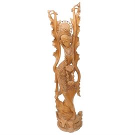 Balinese Sculpture of a Legong Dancer: A large hand carved Balinese wooden sculpture of a Legong dancer. Legong is a traditional form of Balinese dance that originated in the 19th century as entertainment for royals. This piece is hand carved and has no visible markings or signature.