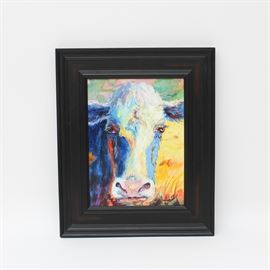"Blue Cow Pink" by Elaine Schulstad: An original oil painting by Elaine Schulstad titled “Blue Cow Pink”. This piece depicts a portrait of a cow in an impressionist style featuring deep blues and bright yellows. It is signed on the lower right side. On the reverse side of this piece is a business card with additional information on the artist.