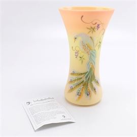 J.K. Spindler Signed Limited Edition Fenton Glass Vase: A limited edition Fenton Connoisseur Collection glass vase, designed by J.K. Spindler. This tapered vase is made of opaque peach and yellow glass. It features a hand-painted white peacock with white, green, and iridescent tail feathers. The underside is signed by numerous Fenton family members and numbered 463/1950. The underside reads “Hand Painted by Frederick.”
