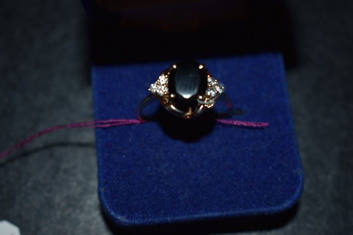 Onyx Ring: One (1) ladies 10kt yellow gold ring mounting weighing approx. 1.8dwt and is set with one (1) oval cut faceted Black Onyx measuring 10mm length, 8mm width. Set on sides of Onyx are six (6) round cut colorless cubic zirconia measuring 2 mm in diameter