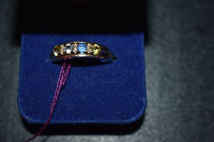 Mother's Ring: One (1) 10kt yellow gold straight line style Mother's Ring mounting weighing approx. 2.04dwt and is set with four (4) synthetic round birthstones each measuring 3.5mm in diameter. One (1) blue, (1) colorless, (2) yellow