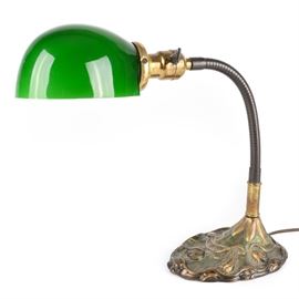 Art Nouveau Goose Neck Lamp by Rose Brothers: An Art Nouveau goose neck lamp manufactured by Rose Brothers. The lamp features a cast iron base with floral motifs highlighted by green and gold paint with an adjustable goose neck. The shade is green glass with a round shape and there is a toggle switch to the neck. Marked “R.B.Co. 8626" to the underside of the base.