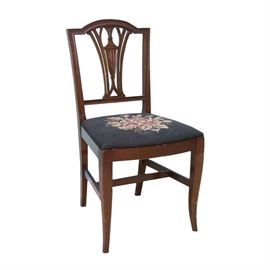 Sheraton Style Parlor Chair With Needlepoint Seat: A Sheraton style parlor chair with a needlepoint seat. This chair features an arched center crest over urn and fan splat back with yoked rail stiles leading to a slip seat with needlepoint floral pattern, bowed front seat support rail and slat seat rail sides. The chair rests on saber legs which taper at the ends and include an attached H-stretcher for support.