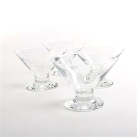 Clear Glass Dessert Dishes: A set of four clear glass dessert dishes. The four pieces feature flared sides that narrow to a small well and short stems on flared feet. The items are unmarked.