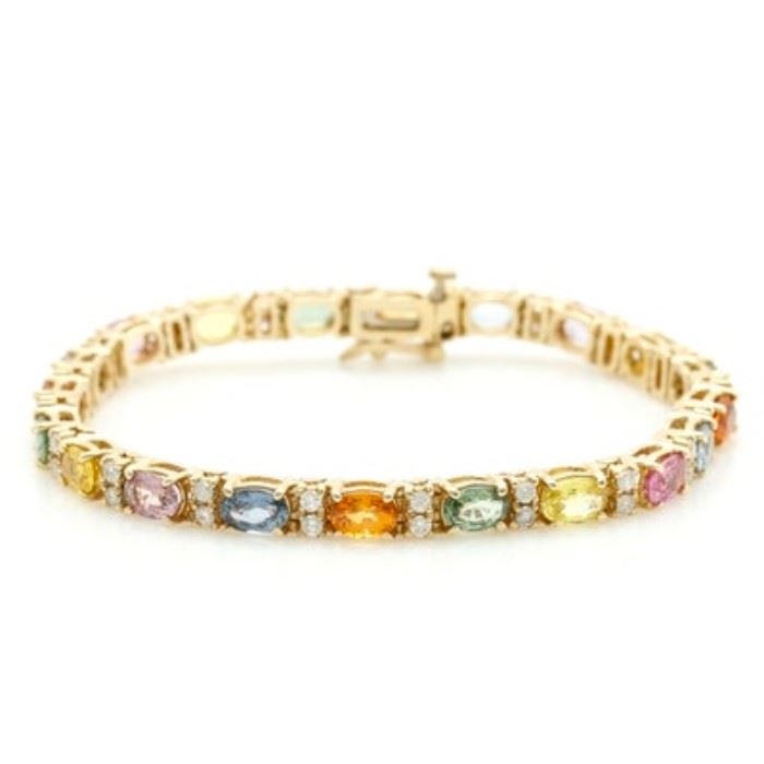14K Yellow Gold 9.60 CTW Fancy Sapphire and 1.00 CTW Diamond Bracelet: A 14K yellow gold 9.60 ctw fancy sapphire and 1.00 ctw diamond bracelet. This bracelet features a row of prong set diamonds alternating with oval blue sapphire, pink sapphire, orange sapphire, green sapphire, yellow sapphire, and lavender sapphire stones.