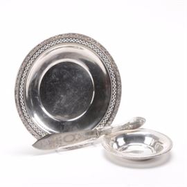 Vintage Sterling Watson and Lunt Serving Pieces With an 800 Silver Knife: A collection of Sterling silver serving pieces by Watson and Lunt together with a hollow handled 800 silver knife. The Watson company was founded in 1880 and were a major maker of a full line of silver until it’s acquisition by Wallace in 1955. The bowl has a reticulated pierced border and repousse’ molding of flowers. There are hallmarks for Watson on the underside consisting of a crown, “W” and lion as well as “Sterling” and" L81" the pattern number. The Lunt bowl pattern 1164 was made during the partnership of Rogers, Lunt & Bowlen. Founded 1901 in Greenfield, Massachusetts, the company used the R.L.B. logo until 1935. This shallow bowl features flared sides with a delicate floral relief around the edge. The bottom is marked “Sterling 1164” . Also included is a hollow handled 8oo silver spoon. with a molded handle and etched blade.