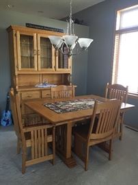 Custom Amish made oak dining set and curio cabinet. Includes two extra leaves for table and six chairs. Made in southern Minnesota. Not on location.