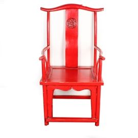 Chinese-Style Red Lacquered Yoke Back Chair: A Chinese-style red lacquered chair. This chair features a yoke back with a carved medallion to the central slat. It has curved arms and arm supports, a serpentine apron, and squared legs with a box stretcher.