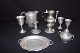 Genuine Pewter Serving Set -9 Pieces:  2 Weighted Leonard challises (5") made in Bolivia; unmarked Pewter chalice (6.5"); 2 candle sticks (1 with a slight malformation) (4.5", 3"); Pewter #4587 water pitcher (dinged) (7"); very unique coffee pot marked Holland Royal Pewter (8"); Genuine Pewter handled sugar bowl (5" dia.); and an oval platter / serving dish (9").  These are in good used condition with some superficial scratches; small and large wine goblets need a little reshaping, which is quite easy ... sit piece(s) out in the sun and pewter becomes very pliable.