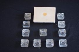 11 Clear Salt Cellars in Original Box: Cellars are 2" x 2" and are 1 inch high. 10 are in mint condition and 1 is chipped.  The label on the box is marked "Henn & Henn Jewelers Chillicothe, Ohio. Originally used for individual salt during the 1920-40's.  An artist could use them for individual paints. This lot is in very good condition and shows little wear, if any.
