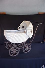 Antique Baby Stroller:  Antique 19thC Victorian (1910-1920) wicker baby buggy stroller pram carriage bassinette size 34" from handle to front edge, 14.5" wide and 18" wide; could also be used for dolls. Stroler has a metal base and cream colored wicker basket.  Moveable bonnet with hard rubber tires and wooden spokes. . Brakes have foot lever which works. Slight surface rust on all metal parts. Wear and tear from use and age, very normal and in good condition for age of item; no lining or isinglass windows. 