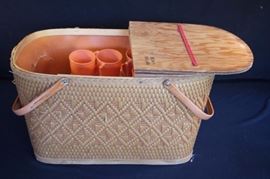Redmond Peru, Ind. Picnic Basket: with orange Colonial Plastics Mfg. Co. Cleveland Ohio and portable mini picnic table.  Orange accessories include 6 each - coffee mugs and divided plates, 4 each - knives, forks & spoons. The basket is slightly damaged on one corner which could be taped from the inside the wooden top could use a little restoration the plastic dishware is ?? in very good condition and shows little wear