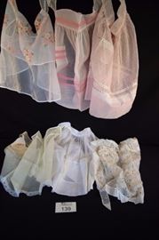 Sweet Hostess Apron Lot:  of 6 hostess aprons; handmade pink organdy trimmed with mini pink & white gingham bias tape with 1 pocket; handmade pink daisy dotted swiss apron trimmed with silver and pink ribbon and lace with 1 pocket; handmade white nylon accented with bright pink floral and ribbon design with 1 pocket; off white with mini daisy design with white ruffles at waste bandand edge (some stains );light yellow with lace pocket and hem (includes vintage hankie); handmade white organdy apron with ribbon waistband open work and embroidered body with pin striped border. All in good vintage condition, no rips, stains or holes.