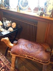It is an authentic camel saddle...repurposed into a bench...carved into the image of a small camel. A consolation purchase for those of us currently without an actual camel.