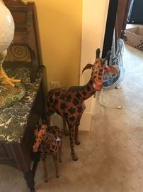 two giraffes hang in the doorway.