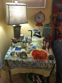 a table in the bedroom with a gorgeous lamp. Everything from gnomes to birds are for sale.