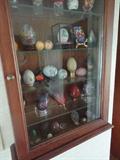 in the entry hall, a collection of oriental eggs in all materials- the wall cabinet is for sale too