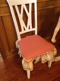 One of three white chairs with upholstered seats