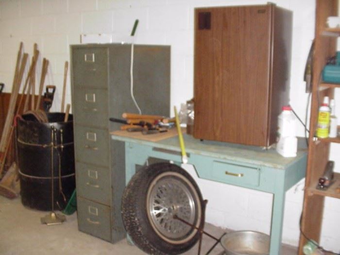 Metal file cabinet; tire; small fridge; utility table with one drawer