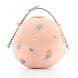 Hand Thrown Stoneware Decorative Jar by Laura Ross: A hand thrown stoneware decorative jar by Laura Ross. This jar is presented in an oblong sphere form with a removable inset lid, two handles applied to the sides and a handle comprised of bent reed presented in pastel shades. The jar features abstract detailing throughout the bisqued surface in gold tone, teal, purple, and green with the signature “Laura Ross” to the underside.