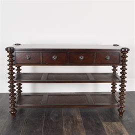 American Signature Console Table: A console table by American Signature. This table features a simple rectangular top with two dovetailed drawers and knob pulls with silver tone backplates. Two open shelves with wicker panels are present between four bobbin-turned legs with turnip feet. It is marked “American Signature” to a label on the interior of a drawer.